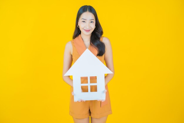 Portrait de belle jeune femme asiatique avec signe de papier maison ou maison