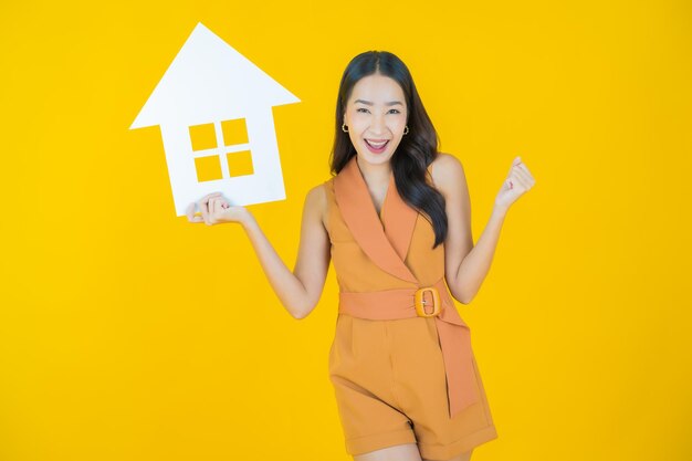 Portrait de belle jeune femme asiatique avec signe de papier maison ou maison