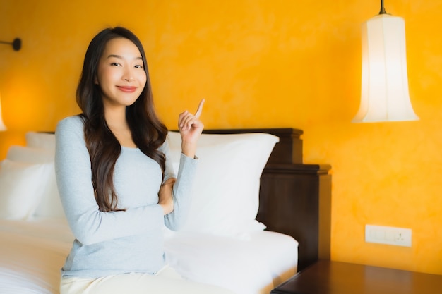 Portrait de la belle jeune femme asiatique souriante sur lit