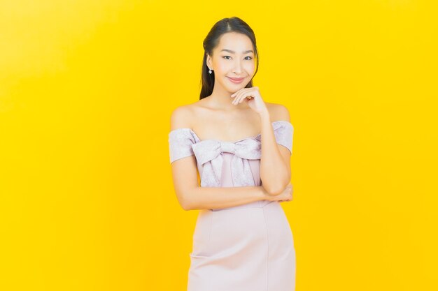 Portrait belle jeune femme asiatique souriante et posant sur un mur de couleur