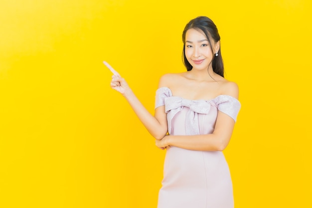 Portrait belle jeune femme asiatique souriante et posant sur un mur de couleur