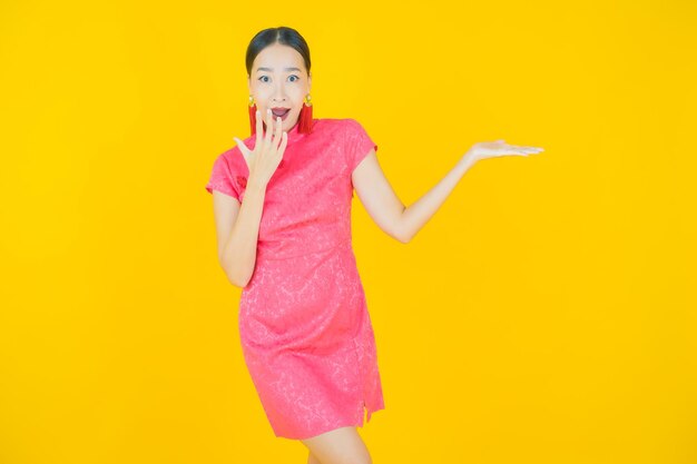 Portrait belle jeune femme asiatique sourire avec action sur fond de couleur