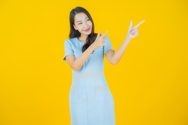 Portrait belle jeune femme asiatique sourire avec action sur fond de couleur