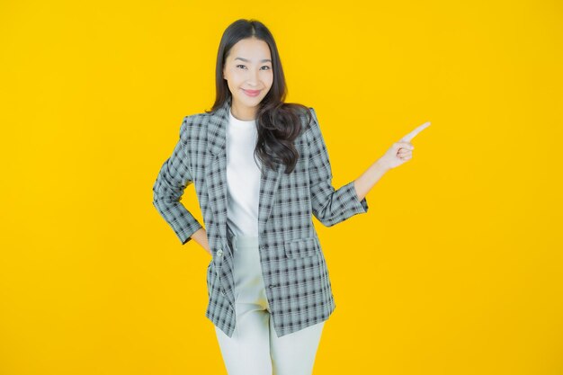 Portrait belle jeune femme asiatique sourire avec action sur fond de couleur