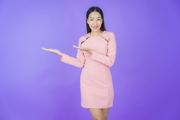 Portrait belle jeune femme asiatique sourire avec action sur fond de couleur
