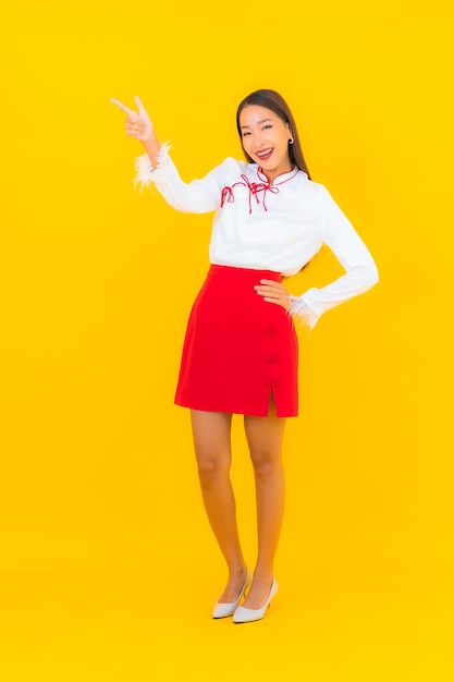 Portrait belle jeune femme asiatique sourire en action sur jaune