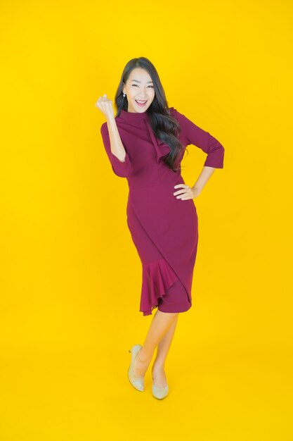 Portrait belle jeune femme asiatique sourire avec action sur jaune