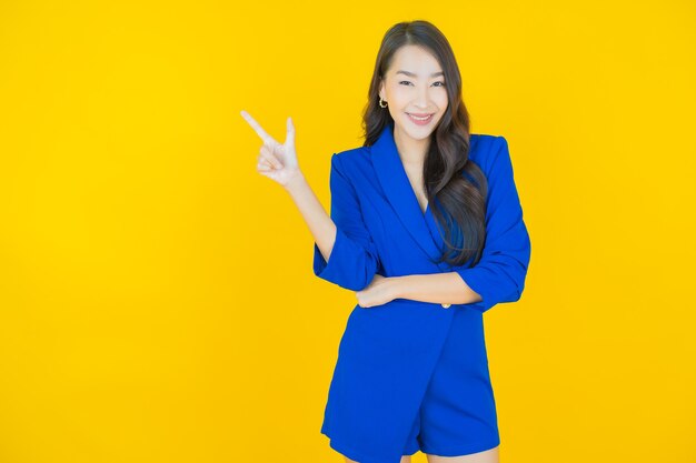 Portrait belle jeune femme asiatique sourire avec action sur jaune