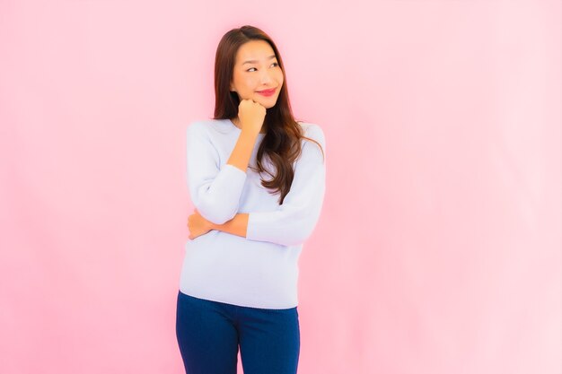 Portrait belle jeune femme asiatique sourire avec action sur mur isolé rose
