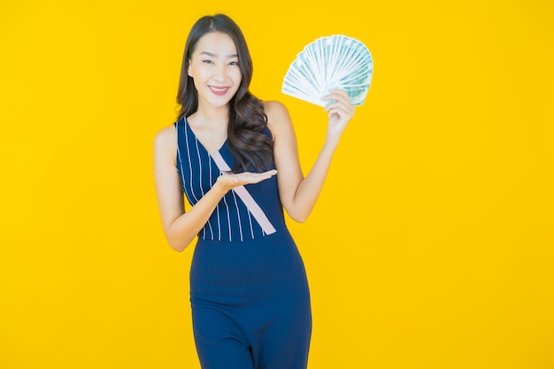 Portrait belle jeune femme asiatique sourire avec beaucoup d'argent et d'argent dessus