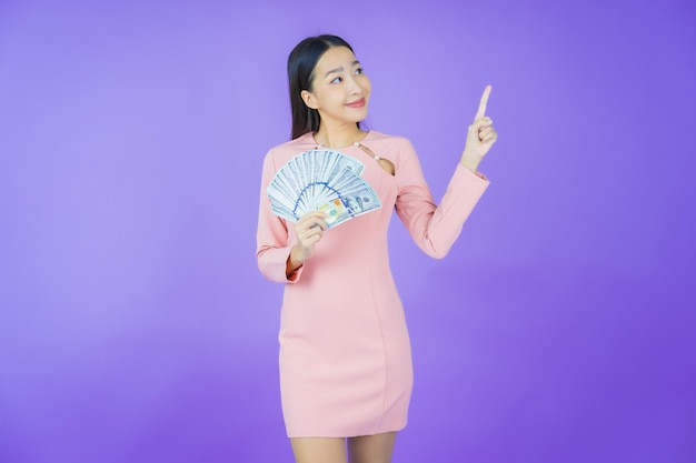 Portrait Belle Jeune Femme Asiatique Sourire Avec Beaucoup D'argent Et D'argent Sur Fond De Couleur Photo gratuit