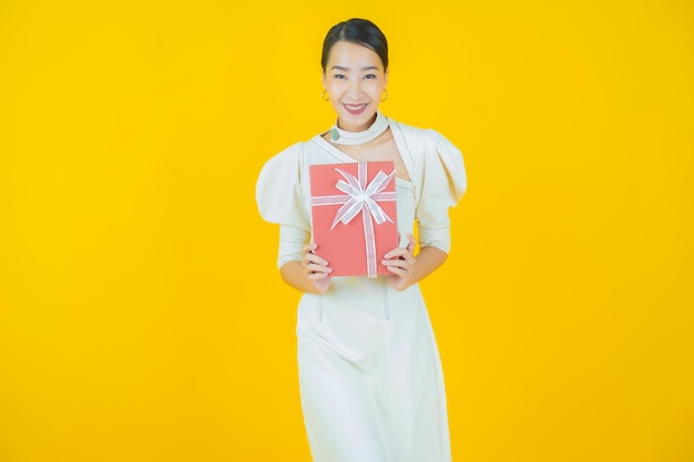 Portrait Belle Jeune Femme Asiatique Sourire Avec Boîte-cadeau Rouge Sur Fond De Couleur