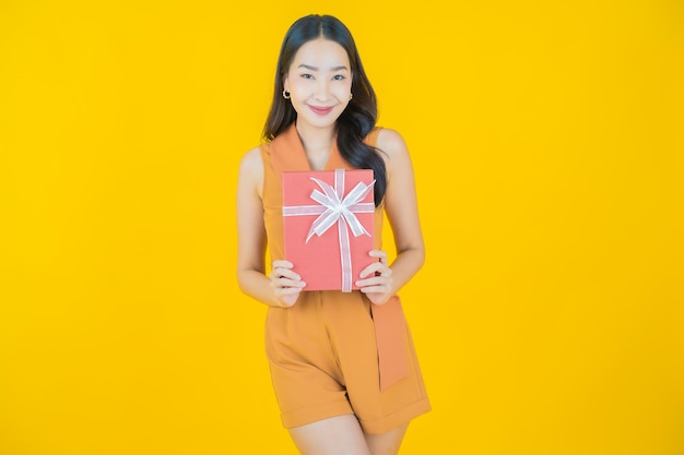 Portrait de la belle jeune femme asiatique sourire avec boîte-cadeau rouge