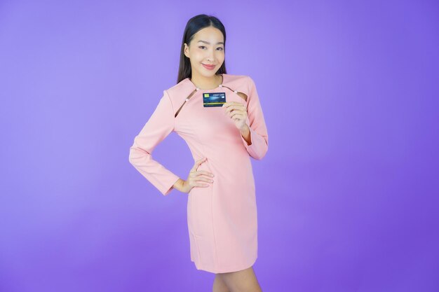 Portrait belle jeune femme asiatique sourire avec carte de crédit sur fond de couleur