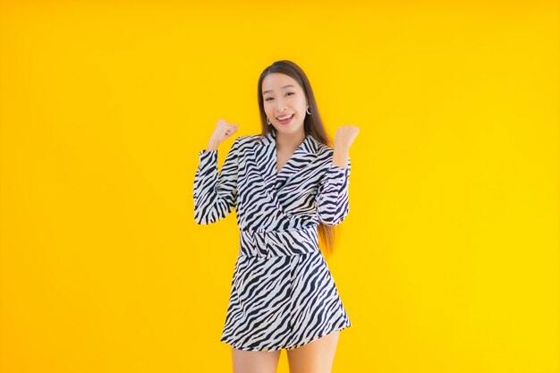 Portrait belle jeune femme asiatique sourire heureux avec action sur jaune