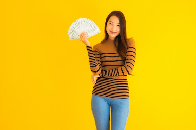 Portrait belle jeune femme asiatique sourire heureux et riche avec beaucoup d'argent dans sa main