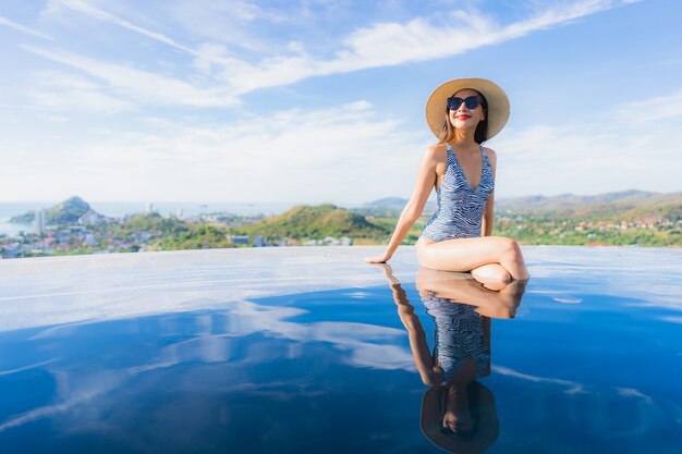 Photo gratuite portrait belle jeune femme asiatique sourire heureux se détendre autour de la piscine dans l'hôtel resort pour les loisirs