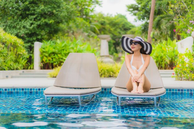 Portrait belle jeune femme asiatique sourire heureux se détendre autour de la piscine dans l'hôtel resort