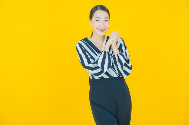 Portrait belle jeune femme asiatique sourire sur jaune