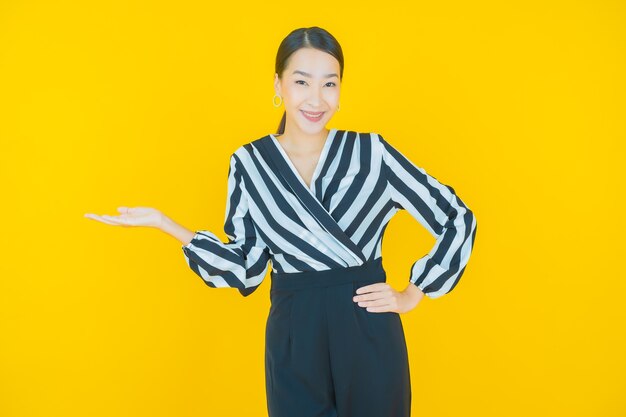 Portrait belle jeune femme asiatique sourire sur jaune