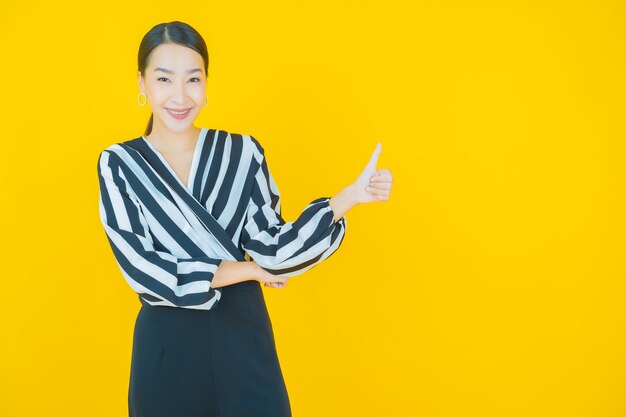 Portrait belle jeune femme asiatique sourire sur jaune