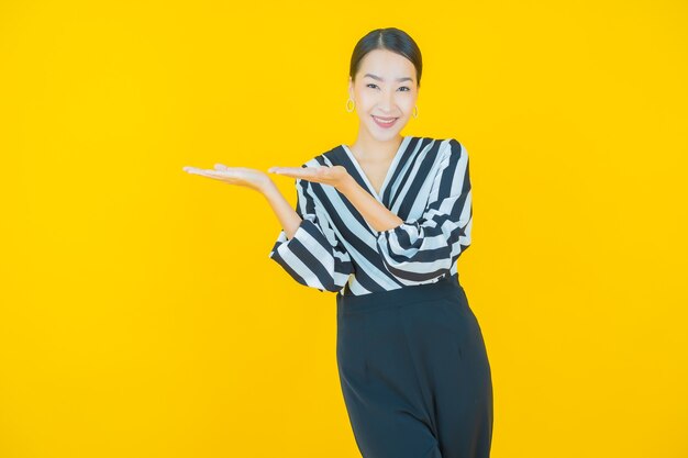 Portrait belle jeune femme asiatique sourire sur jaune