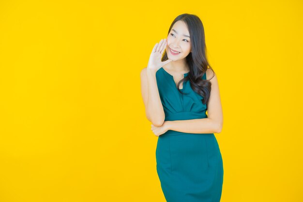 Portrait belle jeune femme asiatique sourire sur jaune