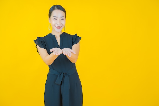 Portrait belle jeune femme asiatique sourire sur jaune