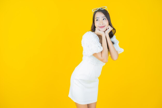 Portrait belle jeune femme asiatique sourire sur jaune