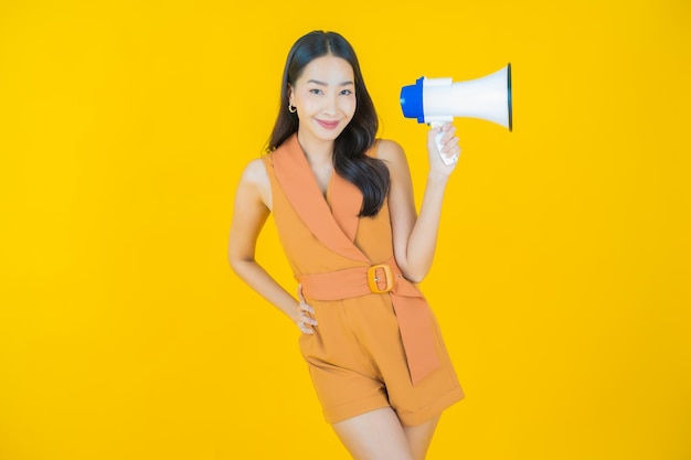 Portrait de la belle jeune femme asiatique sourire avec mégaphone