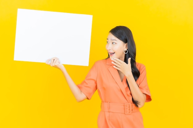 Portrait Belle Jeune Femme Asiatique Sourire Avec Panneau Blanc Vide Sur Jaune