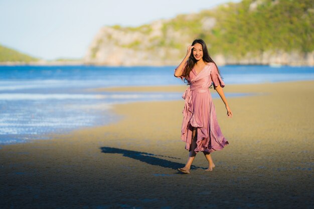 Portrait belle jeune femme asiatique sourire promenade heureuse sur la mer tropicale en plein air nature plage