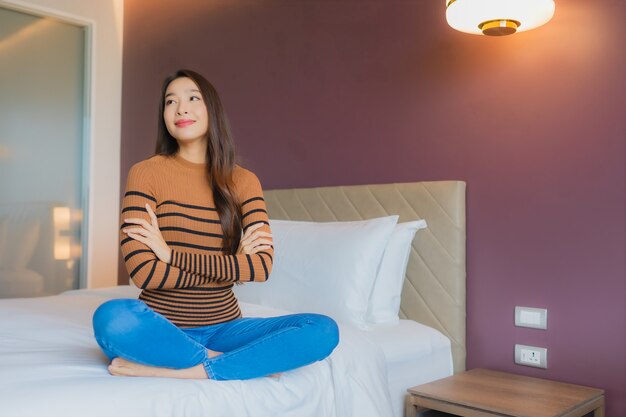 Portrait belle jeune femme asiatique sourire se détendre sur le lit