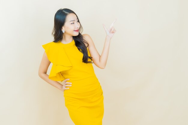 Portrait belle jeune femme asiatique sourit sur mur beige