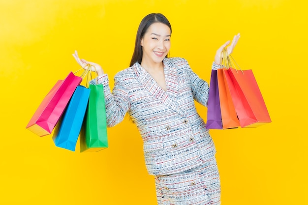 Portrait belle jeune femme asiatique sourit avec panier sur mur de couleur