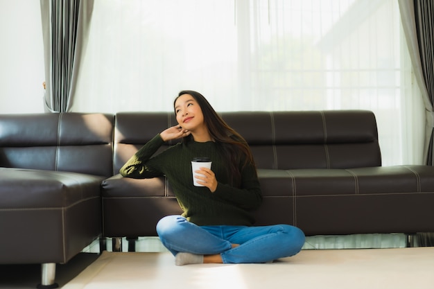 Portrait belle jeune femme asiatique utiliser un téléphone mobile intelligent avec une tasse de café