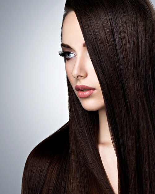 Portrait de la belle jeune femme aux longs cheveux raides au studio