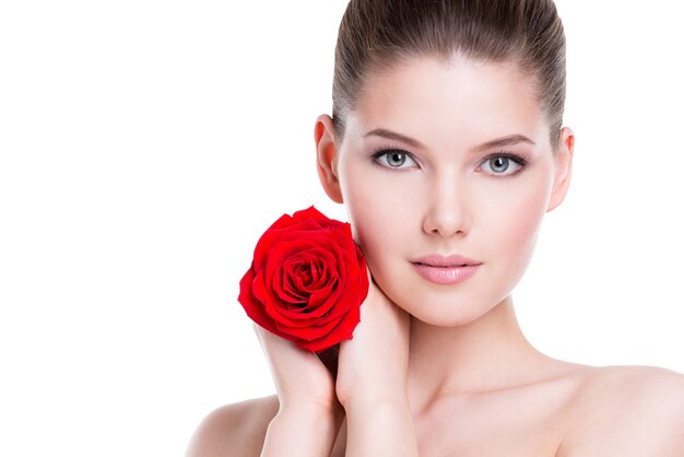 Portrait de la belle jeune femme brune avec une rose rouge près du visage - isolé sur blanc.