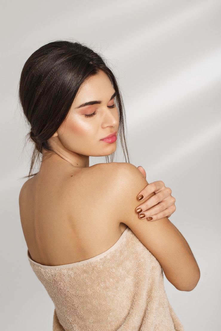 Photo gratuit portrait d'une belle jeune femme chic après spa debout couvert de serviette.