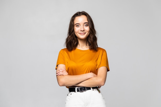 Portrait de la belle jeune femme debout sur un mur gris