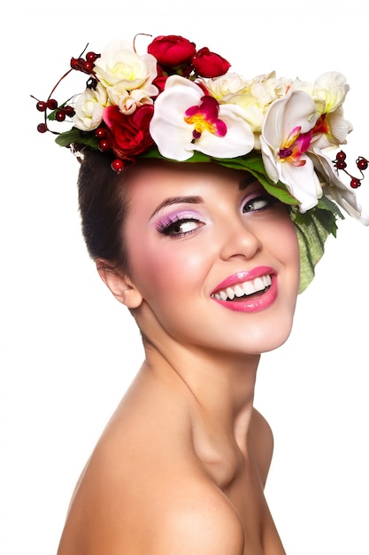 Portrait de la belle jeune femme élégante avec des fleurs colorées sur la tête