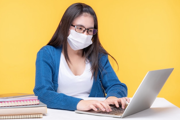 Portrait d'une belle jeune femme étudiant à la table avec un ordinateur portable et un ordinateur portable à la maison - étude du système d'apprentissage en ligne