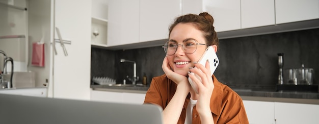 Photo gratuite portrait d'une belle jeune femme gérant sa propre entreprise à domicile freelance faisant un appel téléphonique