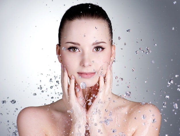 Portrait de la belle jeune femme avec des gouttes d'eau autour de son visage