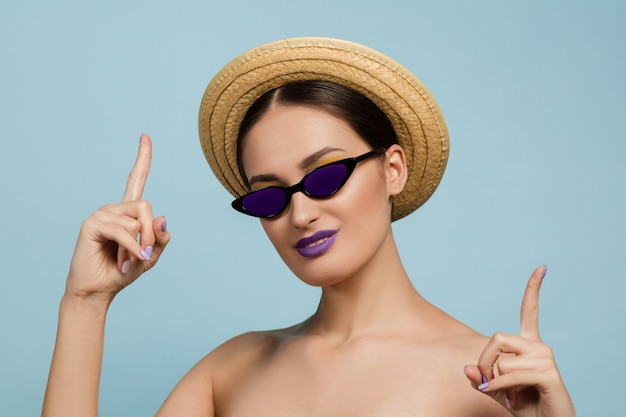 Portrait de la belle jeune femme avec maquillage lumineux isolé sur studio bleu