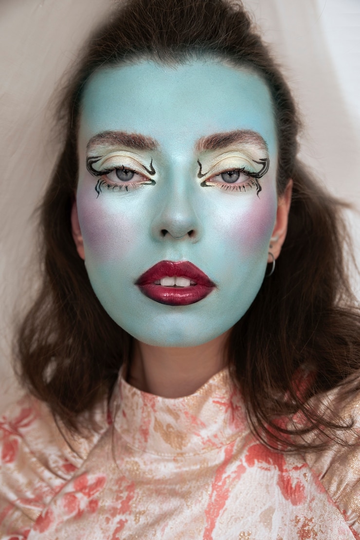 Photo gratuit portrait d'une belle jeune femme avec un maquillage de visage coloré