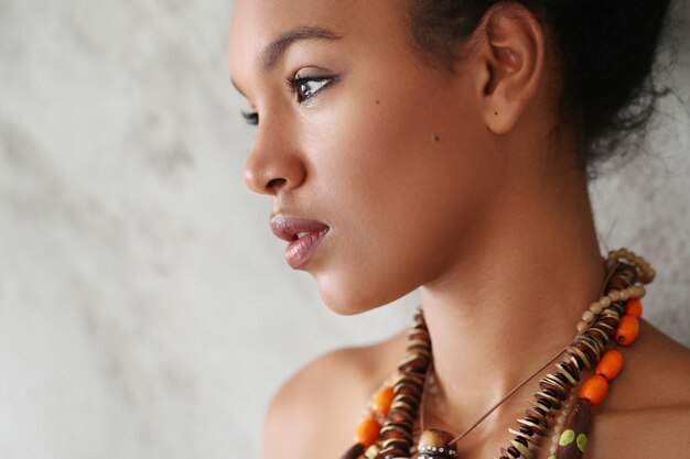 Portrait de la belle jeune femme noire avec collier africain traditionnel