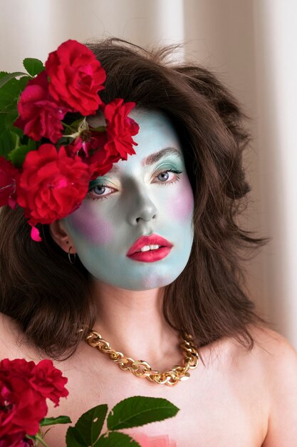 Portrait d'une belle jeune femme avec de la peinture faciale et des fleurs