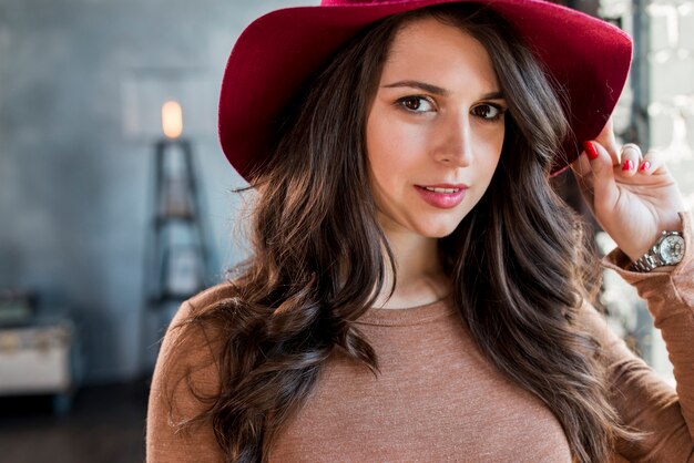 Portrait d&#39;une belle jeune femme portant un chapeau en regardant la caméra