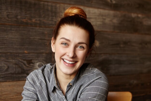 Portrait de la belle jeune femme de race blanche rousse souriant joyeusement